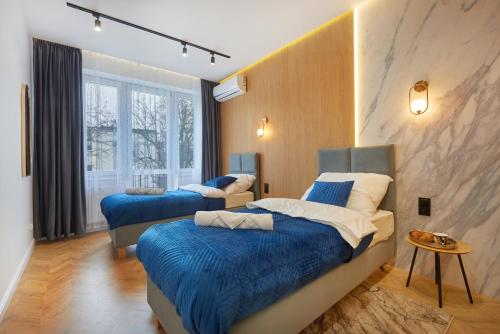 twee bedden in een kamer met blauwe dekbedden bij Buen Home Apartments - Old Town in Rzeszów