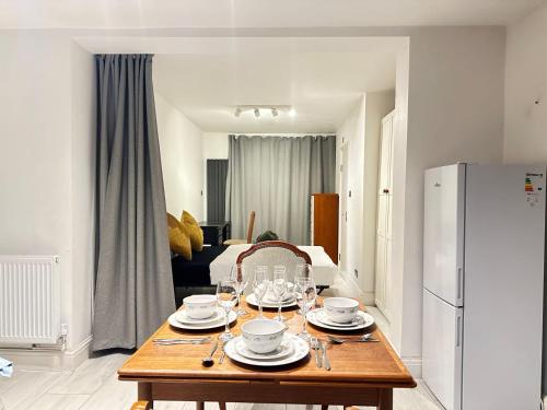 a living room with a table with plates and wine glasses at Large Studio With Extra Sofa Bed and private bath plus kitchen Canary Wharf 1 in London