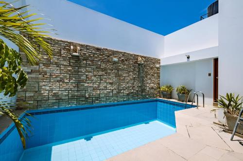 a swimming pool in a house with a brick wall at Hotel Casa de la Luna in Chiclayo