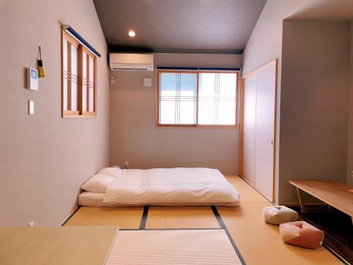 a room with a bed and a window in it at suikakan heianjingumae 酔花間 in Kyoto