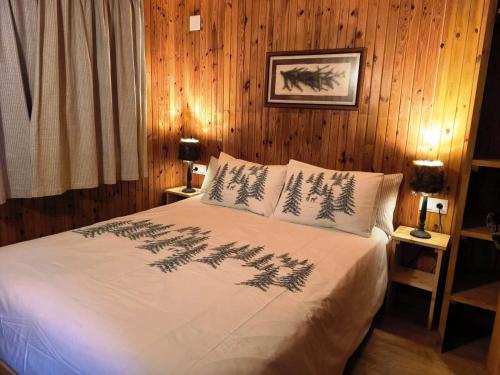a bedroom with a bed with pine trees on it at Aiguestortes Camping Resort in Esterri d'Àneu