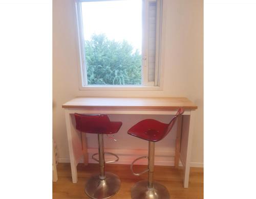 a desk with two red chairs in front of a window at Spacious 3BD Penthouse with Rooftop & Parking in Ra‘ananna