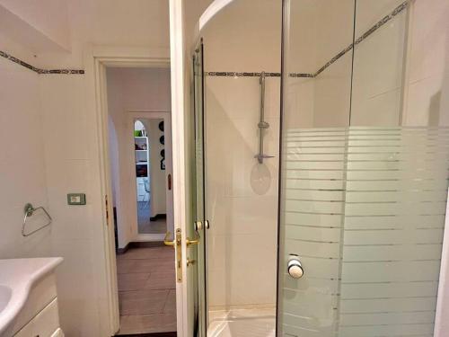 une salle de bain avec une douche avec une porte vitrée dans l'établissement Le Colony, à Cannes