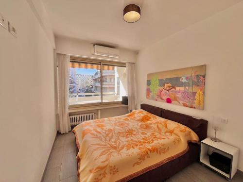 une chambre avec un lit et une fenêtre dans l'établissement Le Colony, à Cannes