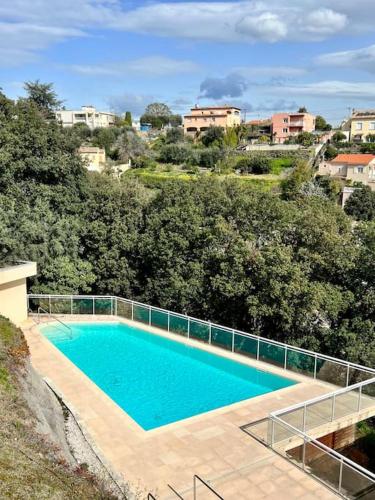 une grande piscine en face de quelques arbres dans l'établissement Appartement vue mer avec garage, à Saint-Laurent-du-Var