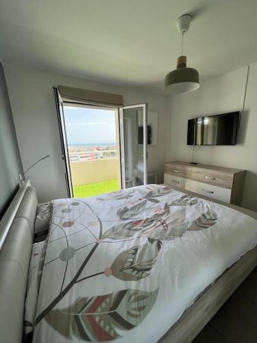 une chambre avec un lit et une grande fenêtre dans l'établissement Appartement vue mer avec garage, à Saint-Laurent-du-Var