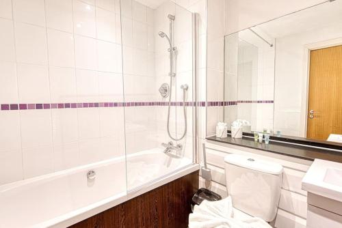 a bathroom with a tub and a toilet and a sink at Guest Homes - Cutlass Court in Birmingham