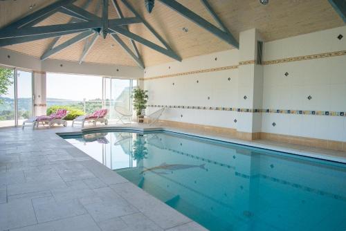 a swimming pool in a house with a ceiling at Les Hauts de Fondanger in Cublac