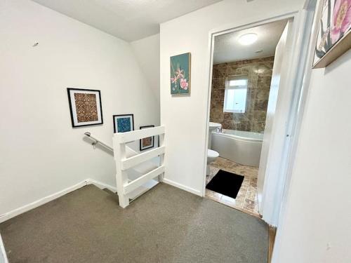 a white bathroom with a tub and a sink at Unique Indian Inspired Townhouse in Great Billing