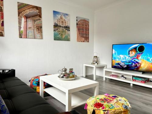 a living room with a couch and a tv at Unique Indian Inspired Townhouse in Great Billing