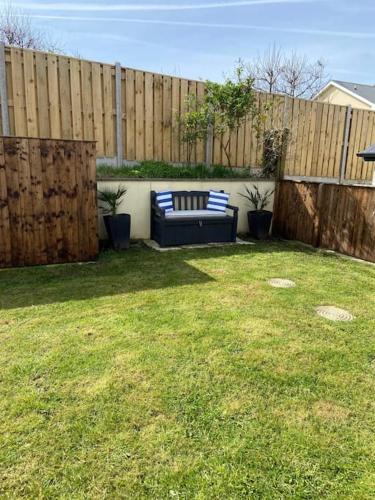 a couch sitting in a yard next to a fence at 2 Headland Place Aberporth (Beautiful sea views, 1 min walk to beach) in Aberporth