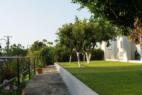 a garden with trees and grass and a building at Hotel Malia Holidays in Malia