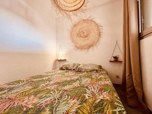 een slaapkamer met een bed met een kleurrijke deken bij Magnifique T2 au calme avec une superbe vue sur le port in Canet-en-Roussillon