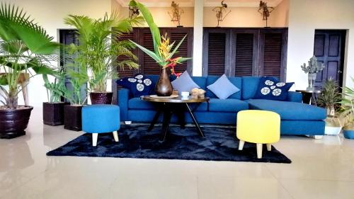 a living room with a blue couch and two chairs at Villa 'The Blue House' - Qbungalows in Kep
