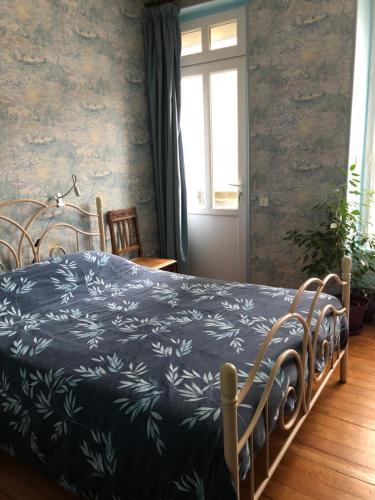 ein Schlafzimmer mit einem Bett mit einer schwarzen und weißen Decke in der Unterkunft 77 Bleu in Balleroy