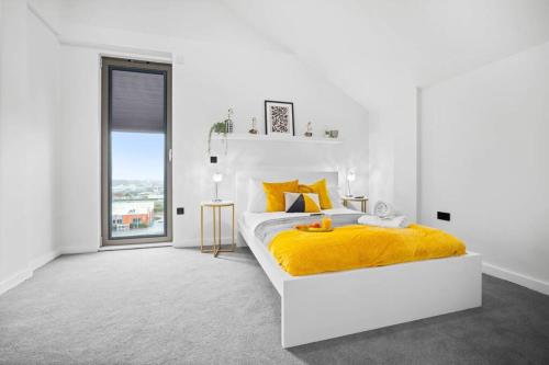 um quarto branco com uma cama com um cobertor amarelo em Urban Retreat in Vibrant Deritend! em Birmingham