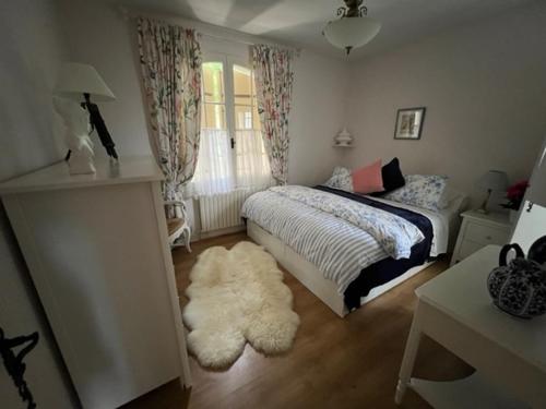 - une chambre avec un lit et un tapis blanc dans l'établissement Maison de Robert, à Saint-Aquilin