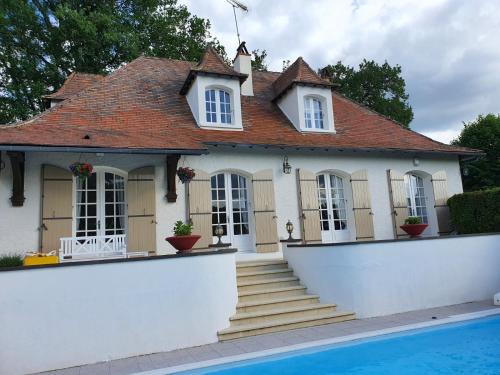 une maison avec une piscine devant dans l'établissement Maison de Robert, à Saint-Aquilin