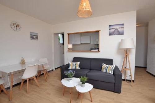 un salon avec un canapé et une table dans l'établissement Les plages du Boucanet, au Grau-du-Roi