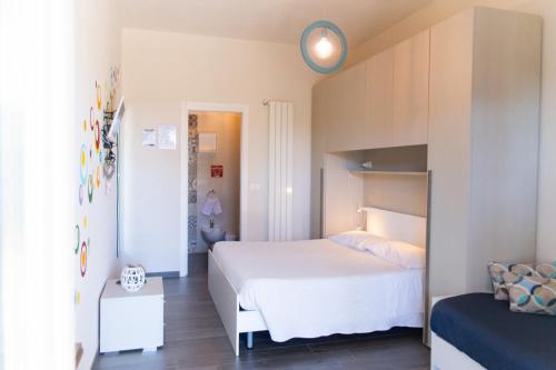 Cette petite chambre comprend un lit blanc et une horloge murale. dans l'établissement Tenuta Amostuni-Country House, à Ostuni