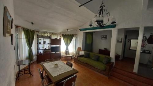 uma sala de estar com um sofá verde e uma mesa em CATALINA em San Antonio de Arredondo