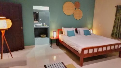 1 dormitorio con 1 cama y baño en Villa 'The Blue House' - Qbungalows, en Kep