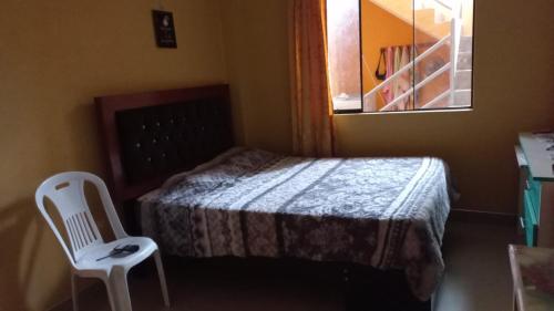 1 dormitorio pequeño con 1 cama y 1 silla blanca en H, en Barranca