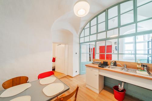 een keuken met een tafel en stoelen en een wastafel bij Hidden Gem with red Door in Wenen
