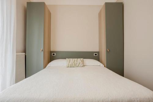 a bedroom with a large bed with white sheets at Villa Arizona in Milano Marittima