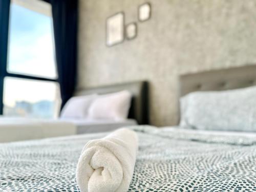 a towel laying on a bed in a bedroom at New Urban Suite Majestics 3BR Homestay at Georgetown BY URBAN STAYCATION HENG LOD in Jelutong