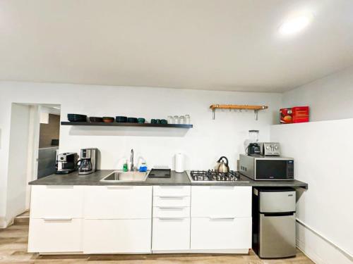 a white kitchen with a sink and a microwave at Cozy Studio Retreat in the Heart of the City in Glendale