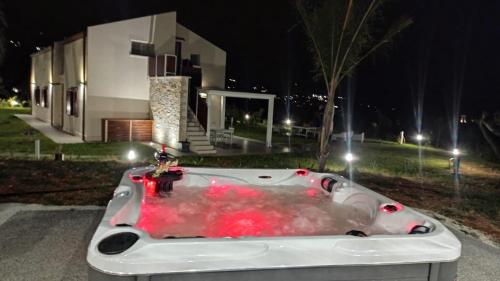 a white bath tub with red fluid in front of a house at Splendida Villa NATURE-APPARTAMENTO MELOGRANO a SCOPELLO-ZINGARO vista sul mare in Scopello