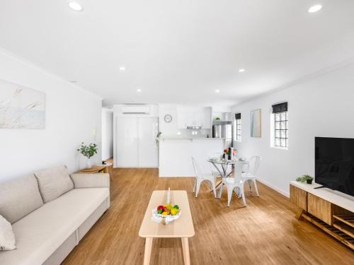 a living room with a white couch and a table at Central 2BR APT for 6PPL w free parking South BNE in Brisbane