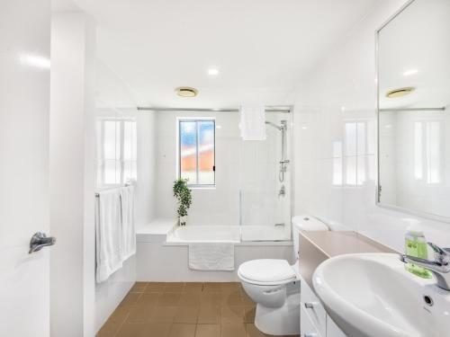 a white bathroom with a toilet and a sink at Central 2BR APT for 6PPL w free parking South BNE in Brisbane