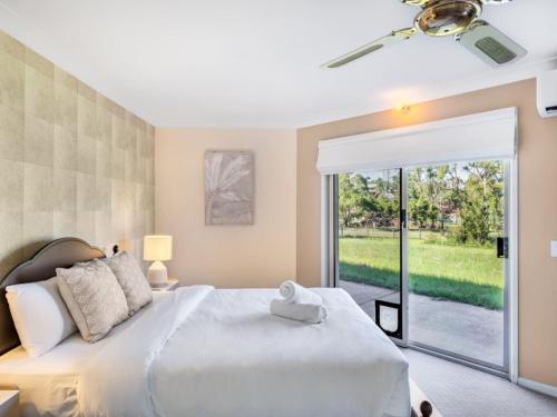 a bedroom with a large bed and a sliding glass door at Modern 4BR Holiday Home W Pool BBQ Oxenford in Gold Coast