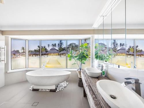 ein Badezimmer mit zwei Waschbecken und einem großen Fenster in der Unterkunft Modern 4BR Holiday Home W Pool BBQ Oxenford in Gold Coast