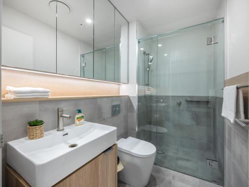 La salle de bains est pourvue de toilettes, d'un lavabo et d'une douche. dans l'établissement Stylish 2BR Haven in West Ends Vibrant Heart, à Brisbane