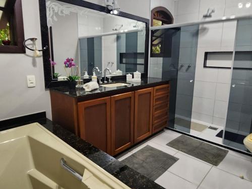 uma casa de banho com uma banheira, um lavatório e um chuveiro em Casa Feliz no Jardim Itaipava, 7 quartos, conforto em Itaipava
