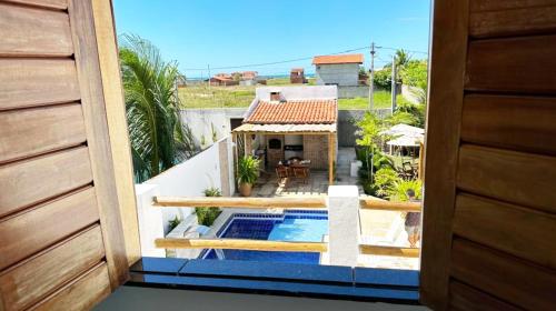 卡斯卡韋爾的住宿－Pousada Maré Forte，阳台享有带游泳池的房屋景致
