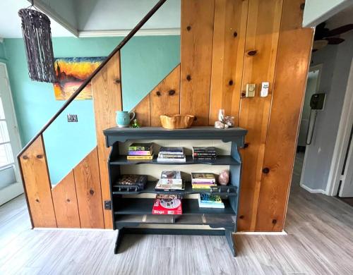 ein Bücherregal in einem Zimmer mit einer Treppe in der Unterkunft Sweet Sunny Summit House in Greensboro