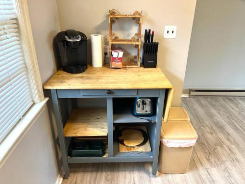a small blue table with a counter top and a trash can at Sweet Sunny Summit House in Greensboro
