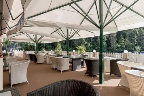 a restaurant with tables and chairs under umbrellas at Gasthof Ambachhof in Oetz