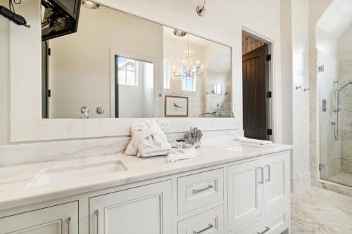 a bathroom with two sinks and a large mirror at License To Chill in Seagrove Beach