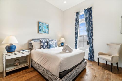 a bedroom with a bed and a chair and a window at License To Chill in Seagrove Beach