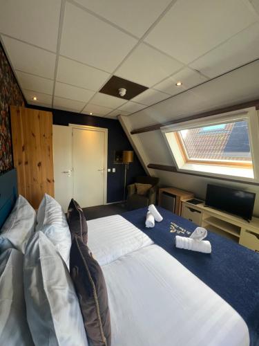 een groot bed in het midden van een boot bij Hotel West Inn in Hippolytushoef