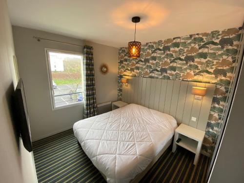 une petite chambre avec un lit et une fenêtre dans l'établissement Chez Elisa - Dans Résidence 4 étoiles à Concarneau, à Concarneau