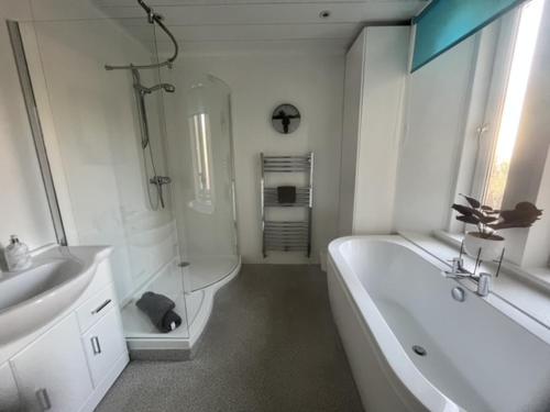 La salle de bains est pourvue d'une baignoire, d'une douche et d'un lavabo. dans l'établissement East Nook, à Anstruther
