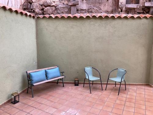 2 Stühle und eine Bank auf einer Terrasse in der Unterkunft Apartamento Robledo de Chavela Plaza 1A in Robledo de Chavela