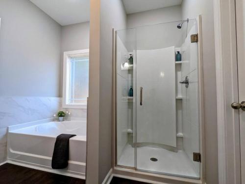 een witte badkamer met een bad en een douche bij Spacious Family Friendly Home with Large Fenced in Yard in Charlotte