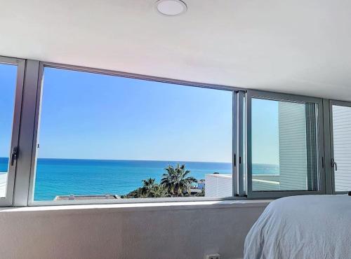 a bedroom with a view of the ocean at Duplex vistas mar con piscina in Sant Pere de Ribes